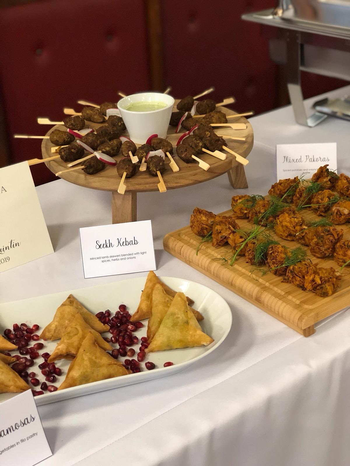 Platter of seekh kebabs served alongside pakoras and samosas at a catered event
