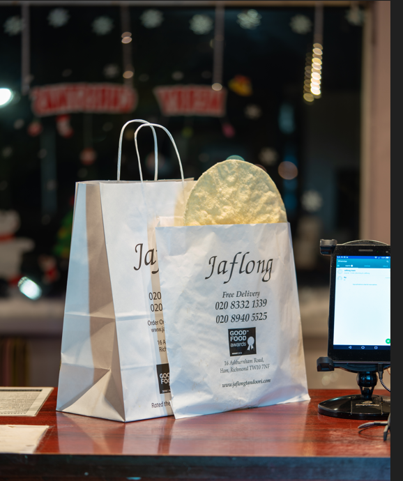 Photograph 4 of 6: Sealed takeaway bags packed and labelled on the counter at Jaflong Tandoori