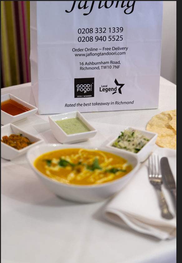 Jaflong Tandoori takeaway bag beside a bowl of curry, chutneys and poppadoms ready for collection in Richmond