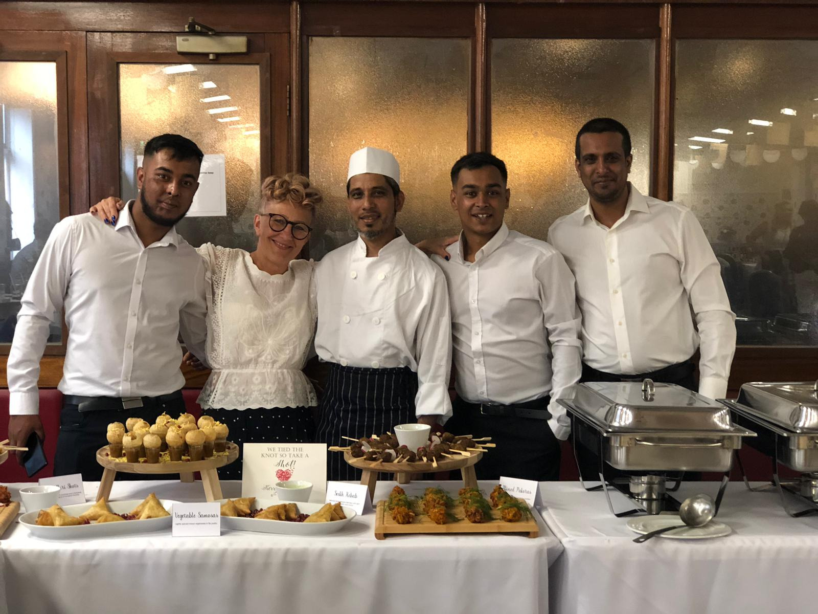 Jaflong Tandoori catering team with the bride beside a fully laid wedding buffet table