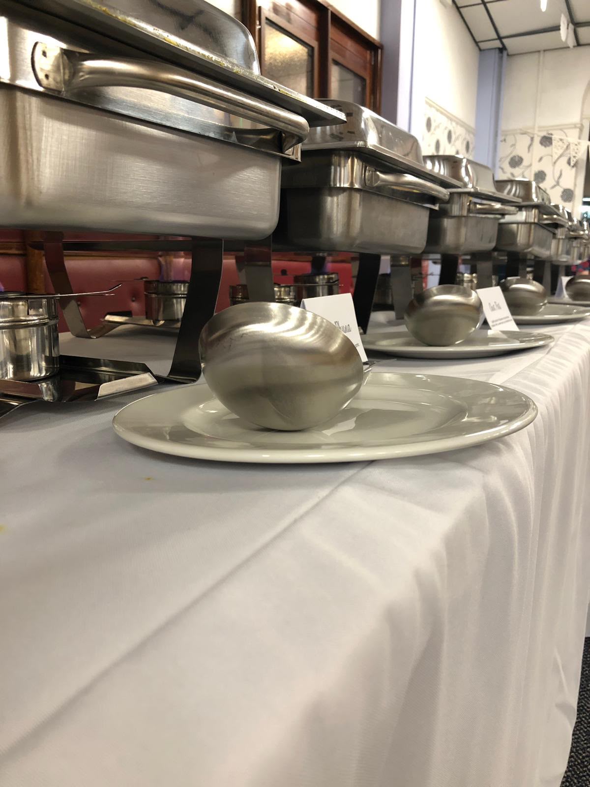 Jaflong Tandoori catering chafing dishes lined up with labelled dishes at a Richmond event
