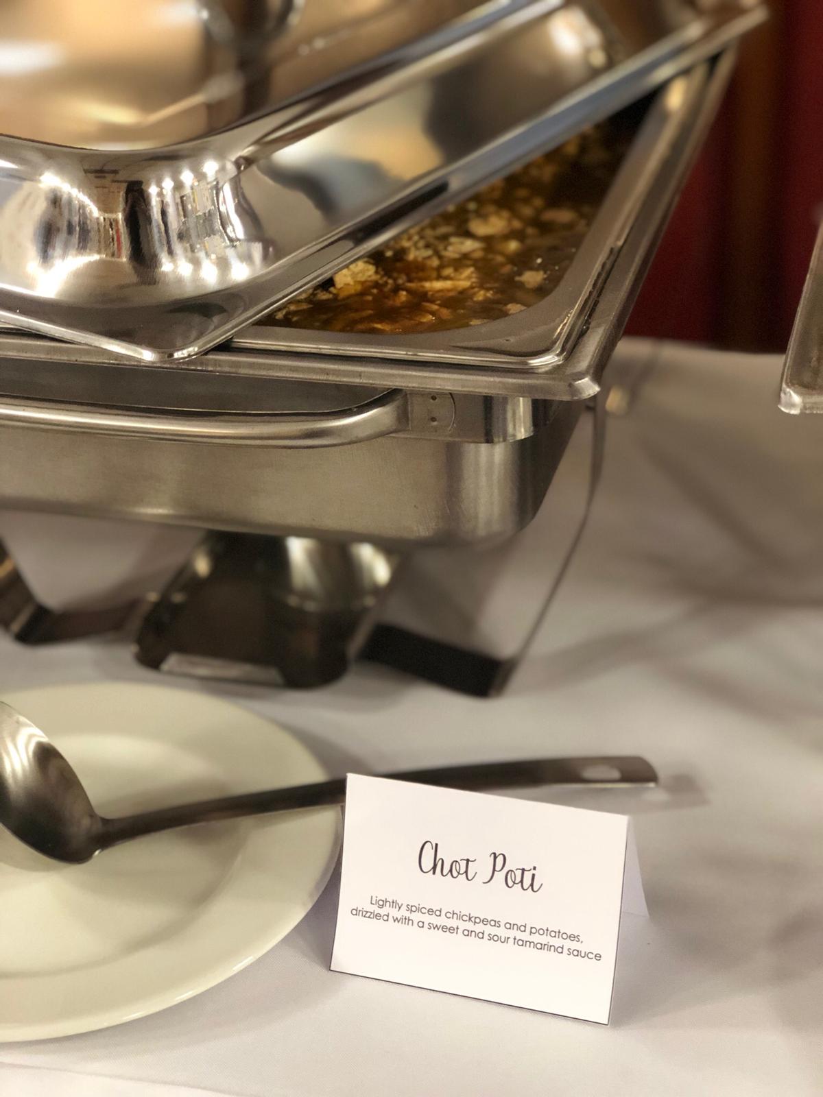 Chot poti chickpea and potato dish served from a chafing dish with a printed name card